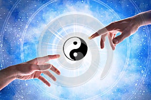 Hands pointing taoist symbol with blue universe background