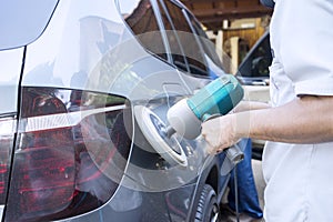 Hands polishing car with auto polisher photo