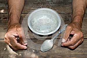 hands the poor old man& x27;s and empty bowl on wood background. The