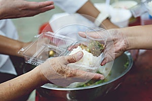 Hands of the poor receive food from the donor`s share. poverty concept