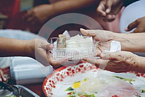 Hands of the poor receive food from the donor`s share. poverty concept