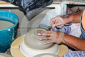 Hands of a potter, creating an bowl on the circle