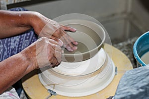 Hands of a potter, creating an bowl on the circle