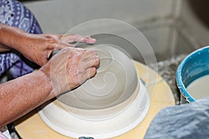 Hands of a potter, creating an bowl on the circle