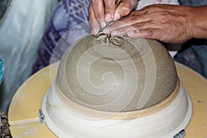 Hands of a potter, creating an bowl on the circle