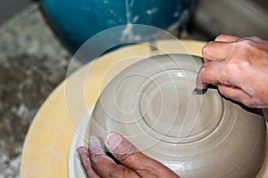 Hands of a potter, creating an bowl on the circle