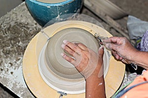 Hands of a potter, creating an bowl on the circle