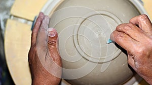 Hands of a potter, creating an bowl on the circle