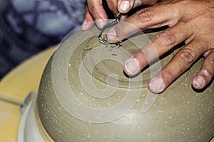 Hands of a potter, creating an bowl on the circle