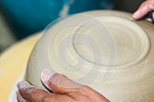 Hands of a potter, creating an bowl on the circle