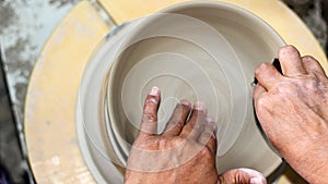 Hands of a potter, creating an bowl on the circle