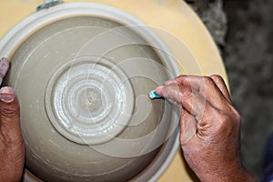 Hands of a potter, creating an bowl on the circle