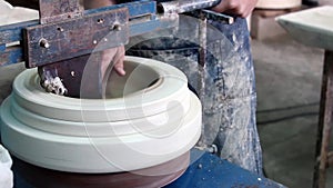 Hands of a potter, creating a bowl using a die, ceramic polishing process