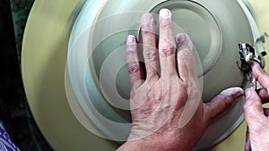 Hands of a potter, creating a bowl using a die, ceramic polishing process