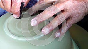 Hands of a potter, creating a bowl using a die, ceramic polishing process