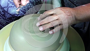 Hands of a potter, creating a bowl using a die, ceramic polishing process