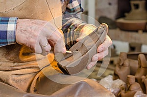 Hands of a potter creating a clay figure