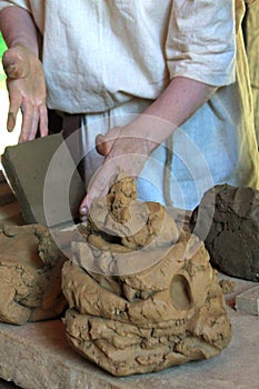 Hands of a potter, creating an clay tile