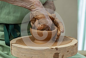 Hands of potter creating a jar