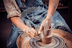 Hands of potter do a clay pot