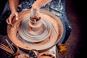 hands of potter do a clay pot