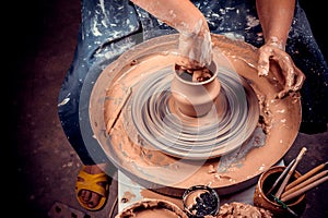 hands of potter do a clay pot