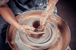 hands of potter do a clay pot photo