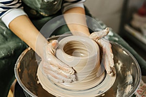 Hands of potter making clay pot on potter`s wheel