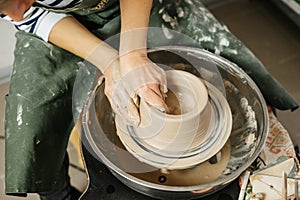 Hands of potter making clay pot on potter`s wheel