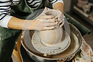 Hands of potter making clay pot on potter`s wheel