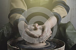 Hands of a potter on a pottery wheel close-up. Old traditional art, handmade, clay and ceramic production. Pottery workshop in