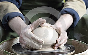 Hands of a potter on a pottery wheel close-up. Old traditional art, handmade, clay and ceramic production. Pottery workshop in