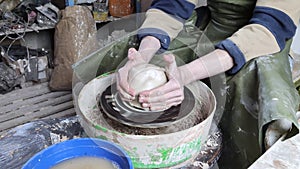 Hands of a potter on a pottery wheel close-up. Old traditional art, handmade, clay and ceramic production. Pottery workshop in