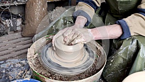 Hands of a potter on a pottery wheel close-up. Old traditional art, handmade, clay and ceramic production. Pottery workshop in