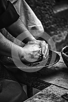 Hands of a potter shaping clay