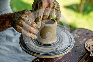 Hands of a potter shaping a clay pot