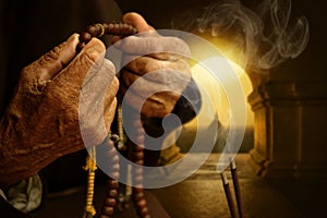 Hands praying between incense sticks