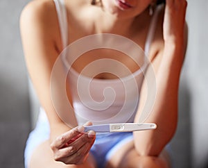 Hands, pregnancy test and woman in bathroom, sad and check for fertility, health and wellness in morning. Girl, person