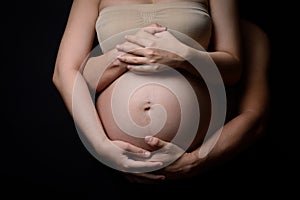 The hands of pregnant woman and her husband on belly