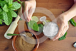 Hands preparing mojito cocktail