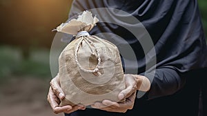 Hands Present a Money Bag for Zakat, Embodying the Islamic Commitment to Help the Poor