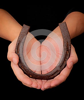 Hands presenting an upright good luck horseshoe