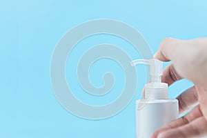 Hands pressing bottles for cleaning cosmetics with copy space on blue background