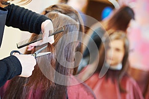 Hands of professional hair stylist with scissors and comb