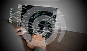 Hands of a programmer types on a laptop displaying programming code, symbolizing coding tech, software development, web