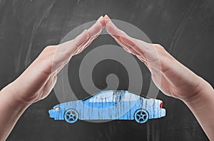 Hands protecting car shape as auto insurance concept