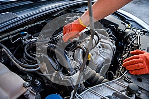 Hands in protective gloves with car engine close up. Car repair concept