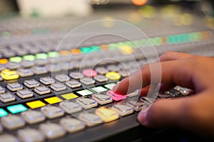 Hands push a button of Switcher buttons in studio TV station, Au
