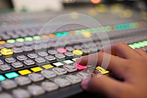 Hands push a button of Switcher buttons in studio TV station, Au