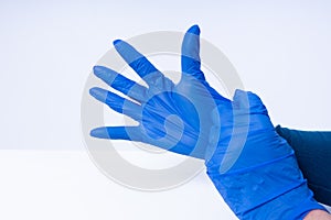 Hands putting on blue nitril gloves